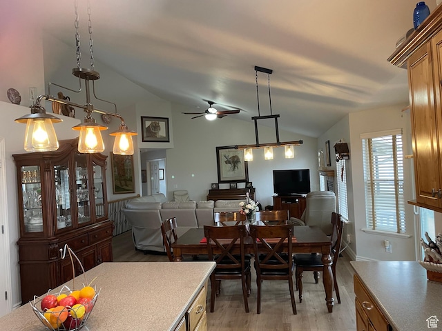 dining area with vaulted ceiling, ceiling fan, and light wood-type flooring