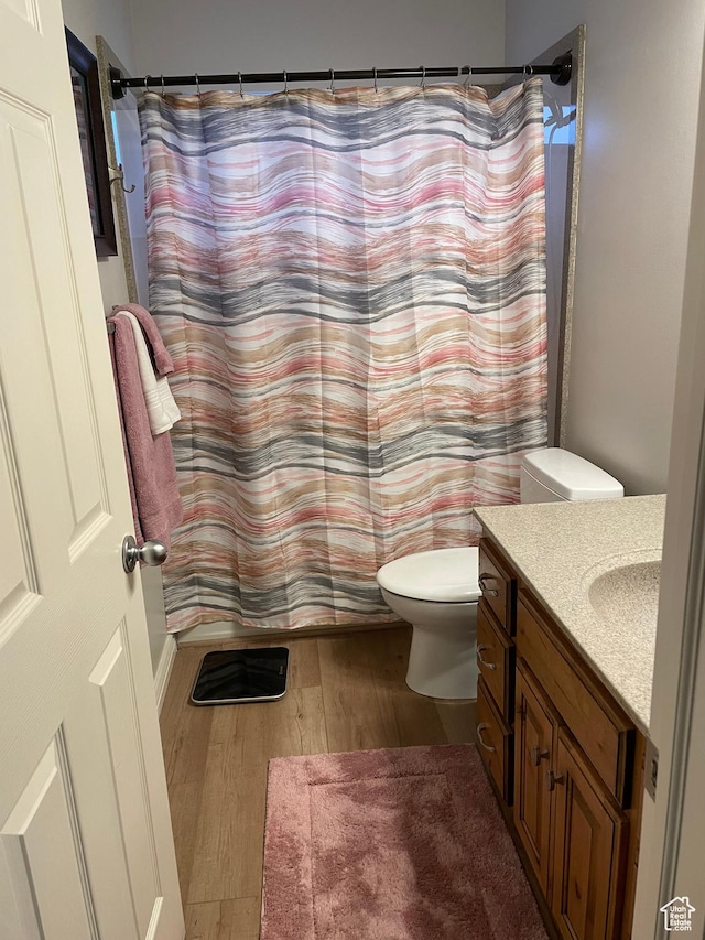 full bathroom with toilet, vanity, a shower with shower curtain, and wood finished floors