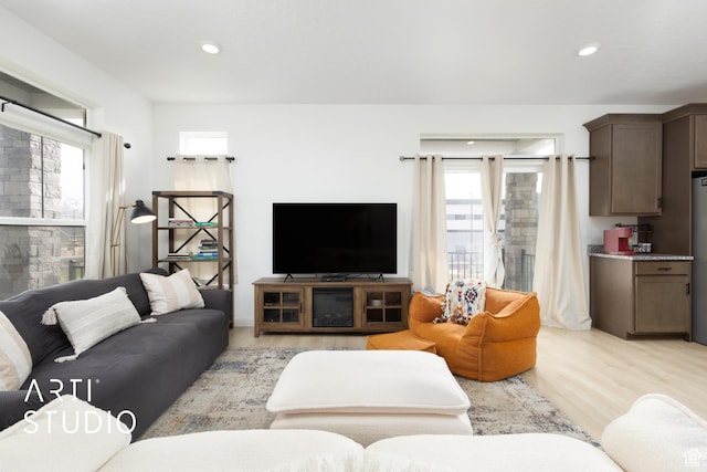 living room with light wood-style flooring and recessed lighting