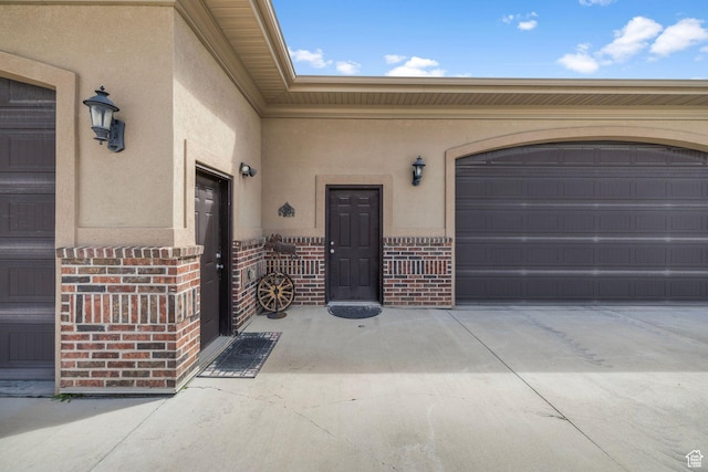 13053 S 1300 W, Riverton, UT 84065 - doorway to property with brick siding, stucco siding, concrete driveway, and an attached garage