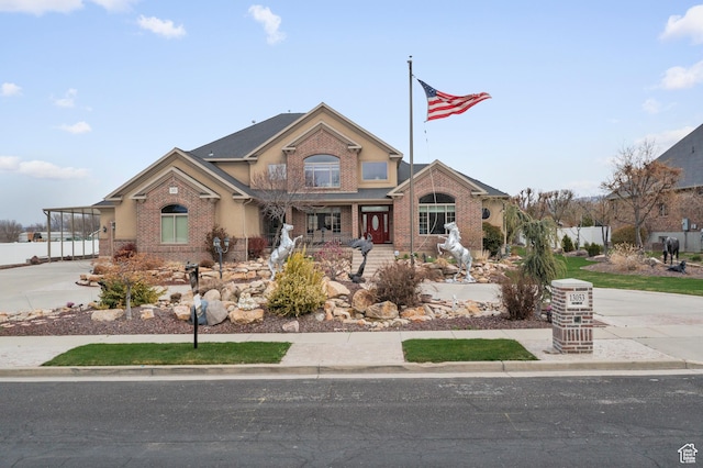 view of front of home featuring fence, brick siding, and concrete driveway