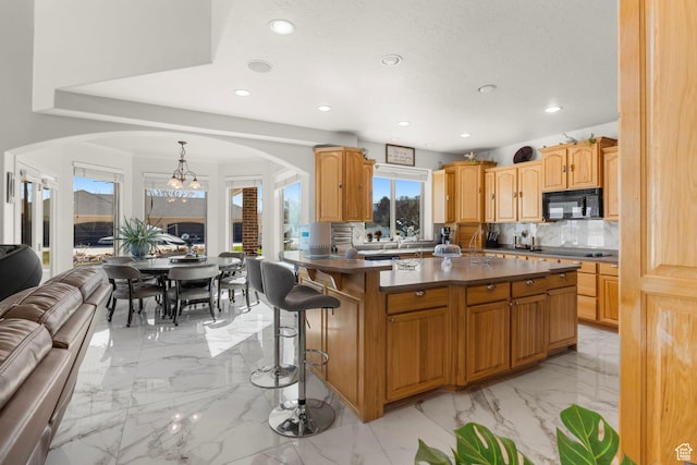 13053 S 1300 W, Riverton, UT 84065 - kitchen with black appliances, arched walkways, light marble finish flooring, dark countertops, and recessed lighting
