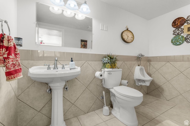 13053 S 1300 W, Riverton, UT 84065 - bathroom featuring toilet, tile patterned floors, a wainscoted wall, and tile walls