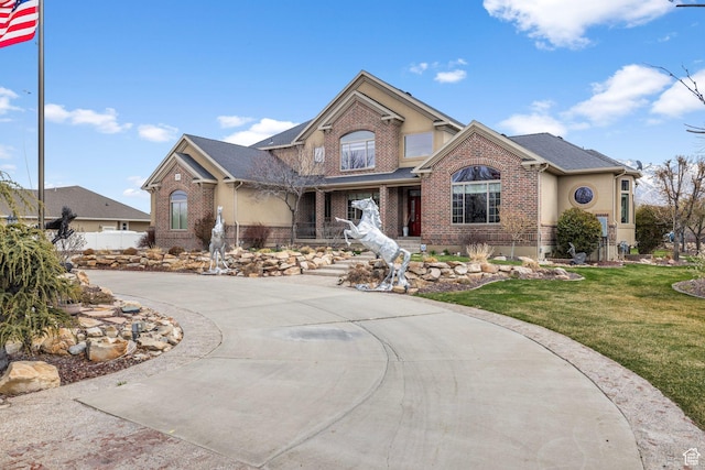 13053 S 1300 W, Riverton, UT 84065 - traditional-style home with brick siding, covered porch, and a front lawn