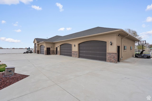 13053 S 1300 W, Riverton, UT 84065 - view of property exterior with concrete driveway, stucco siding, an attached garage, and brick siding