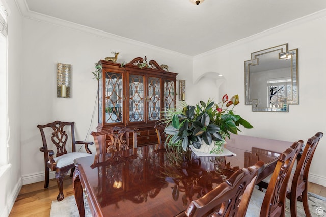 13053 S 1300 W, Riverton, UT 84065 - dining space featuring wood finished floors, ornamental molding, baseboards, and arched walkways