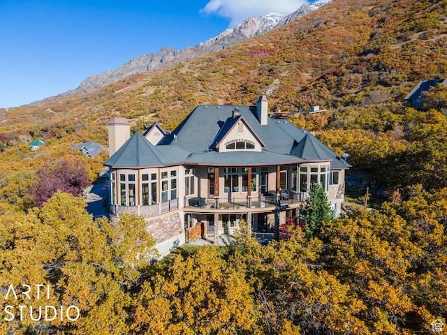5055 Waterfall Dr, Pleasant View, UT 84414 - rear view of property with a sunroom, a mountain view, and a chimney