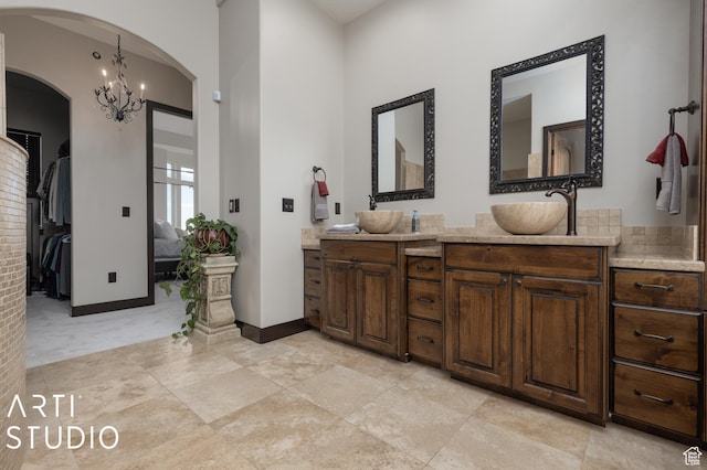 5055 Waterfall Dr, Pleasant View, UT 84414 - full bath with baseboards, double vanity, a sink, and an inviting chandelier