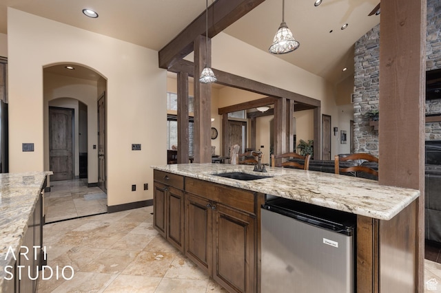 5055 Waterfall Dr, Pleasant View, UT 84414 - kitchen with a sink, arched walkways, light stone counters, pendant lighting, and dishwashing machine
