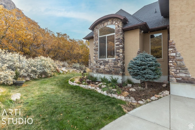 5055 Waterfall Dr, Pleasant View, UT 84414 - view of home's exterior with stone siding, stucco siding, and a yard
