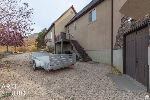 5055 Waterfall Dr, Pleasant View, UT 84414 - view of side of home with stucco siding, a mountain view, and stairway