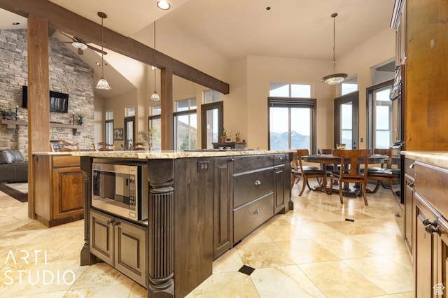 5055 Waterfall Dr, Pleasant View, UT 84414 - kitchen with decorative light fixtures, stainless steel microwave, a center island, light stone counters, and a ceiling fan