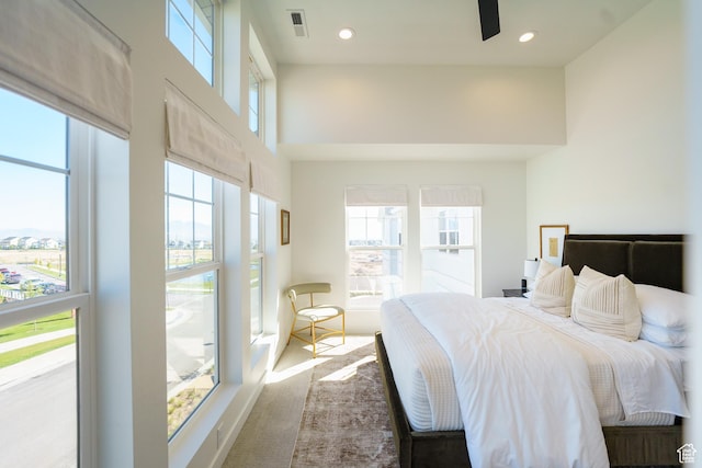 bedroom with multiple windows, a high ceiling, and recessed lighting
