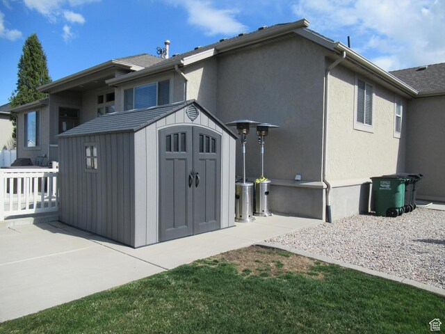 760 S Wellington Dr W, Kaysville, UT 84037 - back of house featuring a patio, an outbuilding, stucco siding, and a storage shed