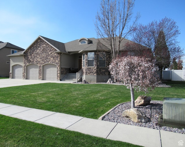 760 S Wellington Dr W, Kaysville, UT 84037 - view of front of house with concrete driveway, fence, an attached garage, stone siding, and a front lawn