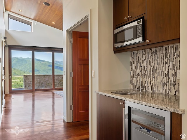 6639 E Chaparral Rd, Huntsville, UT 84317 - kitchen with stainless steel microwave, dark wood-style flooring, backsplash, a sink, and beverage cooler