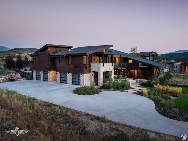 6639 E Chaparral Rd, Huntsville, UT 84317 - view of front facade with a balcony, stone siding, a garage, driveway, and a mountain view