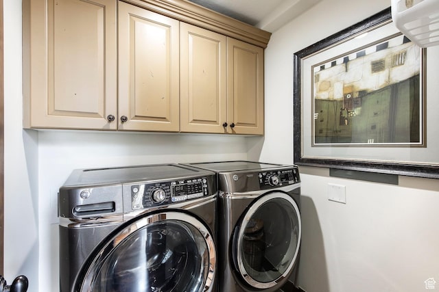 clothes washing area with washer and clothes dryer and cabinet space