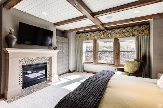 carpeted bedroom featuring a fireplace, recessed lighting, multiple windows, and beam ceiling