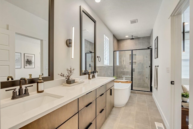 bathroom featuring a shower stall, visible vents, tile patterned floors, and a sink