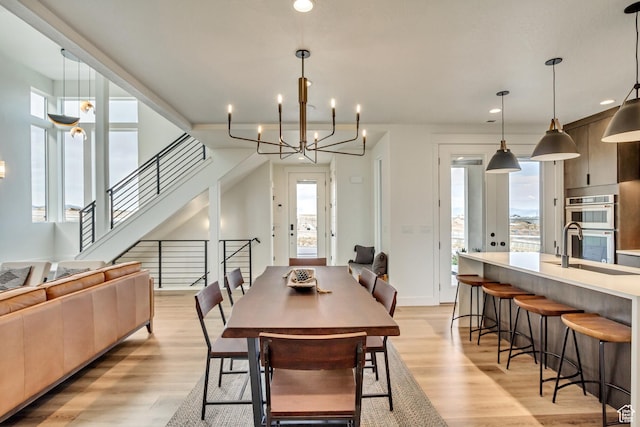 dining room featuring plenty of natural light, an inviting chandelier, and light wood-style flooring