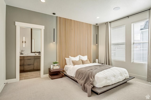 bedroom featuring recessed lighting, carpet floors, baseboards, and ensuite bathroom