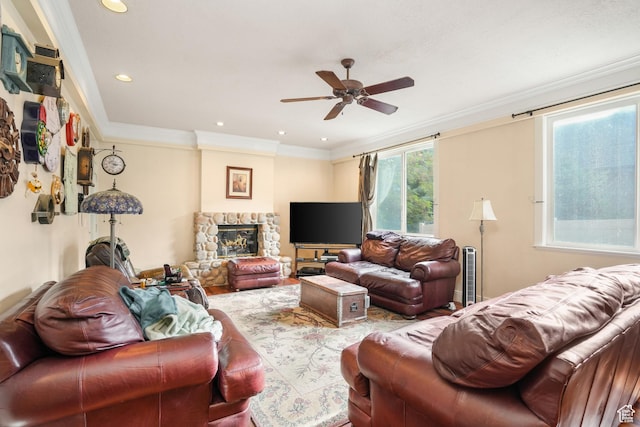 living room featuring ornamental molding, a ceiling fan, a stone fireplace, and recessed lighting