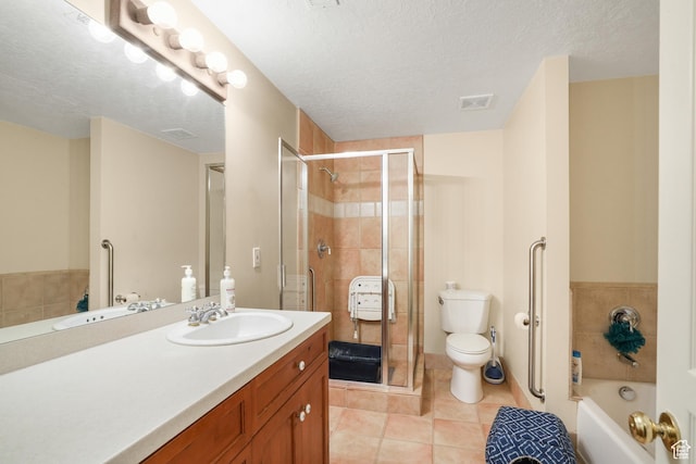 bathroom with a stall shower, tile patterned floors, vanity, and a textured ceiling