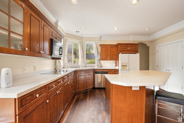 kitchen featuring dark wood-style flooring, a breakfast bar, ornamental molding, a kitchen island, and black appliances