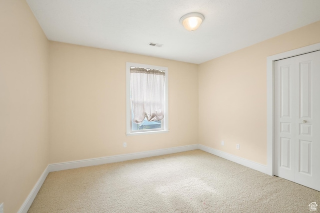 unfurnished bedroom featuring baseboards, visible vents, and carpet