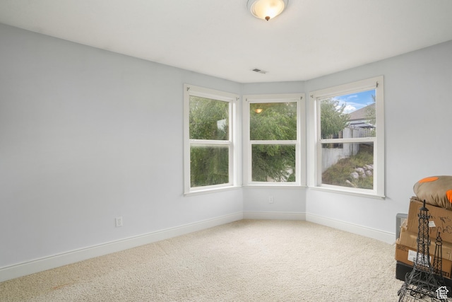 carpeted spare room with baseboards and visible vents