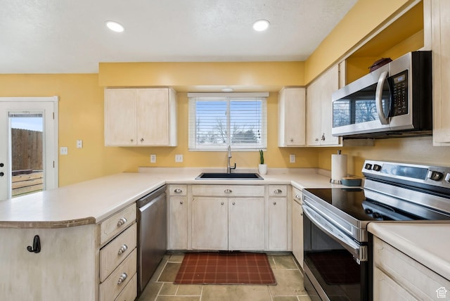 1567 Heather Dr, Layton, UT 84040 - kitchen with light countertops, a sink, stainless steel appliances, and a peninsula