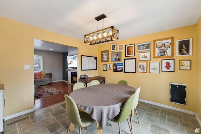 1567 Heather Dr, Layton, UT 84040 - dining room featuring a warm lit fireplace and baseboards