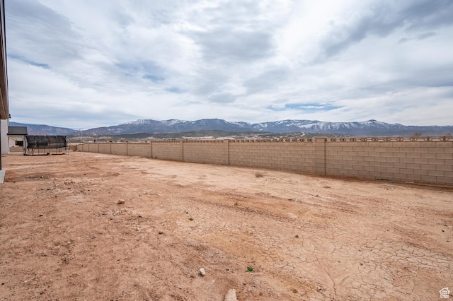 view of yard with fence and a mountain view