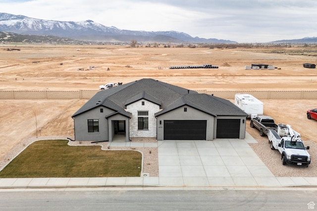 view of front of home featuring driveway, an attached garage, and a mountain view