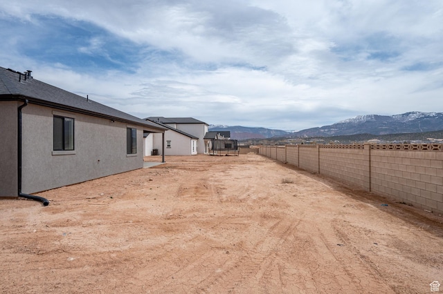 view of yard featuring a mountain view and a fenced backyard