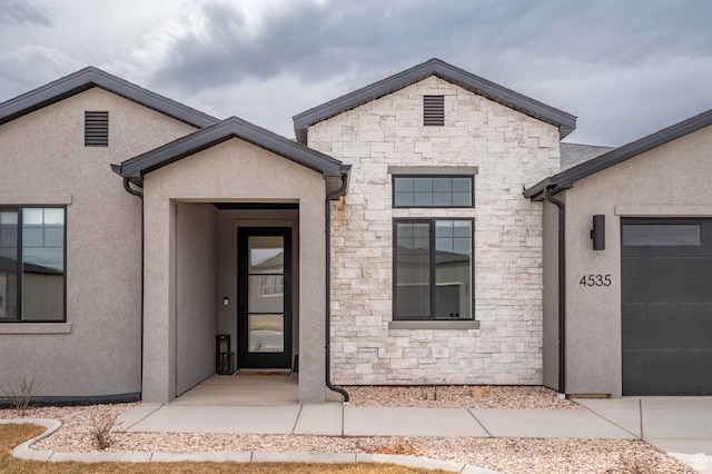 entrance to property featuring stucco siding and stone siding