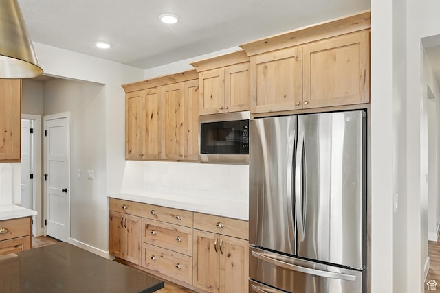 kitchen featuring light brown cabinets, recessed lighting, backsplash, and appliances with stainless steel finishes