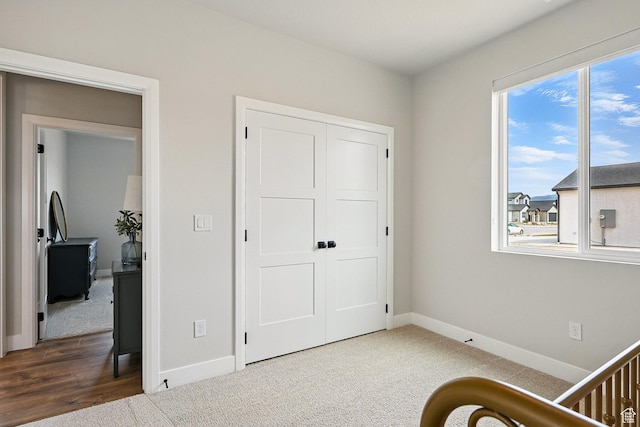 bedroom with baseboards, carpet floors, and a closet