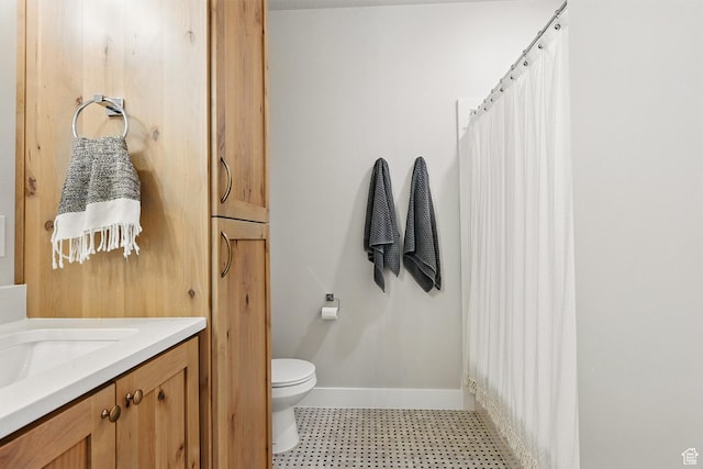 full bath with toilet, vanity, tile patterned floors, and baseboards