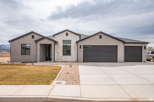 view of front facade featuring a front yard, an attached garage, stucco siding, and concrete driveway