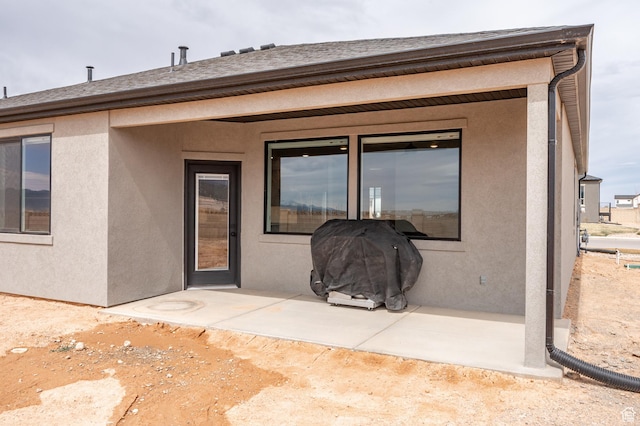 back of house featuring stucco siding and a patio area