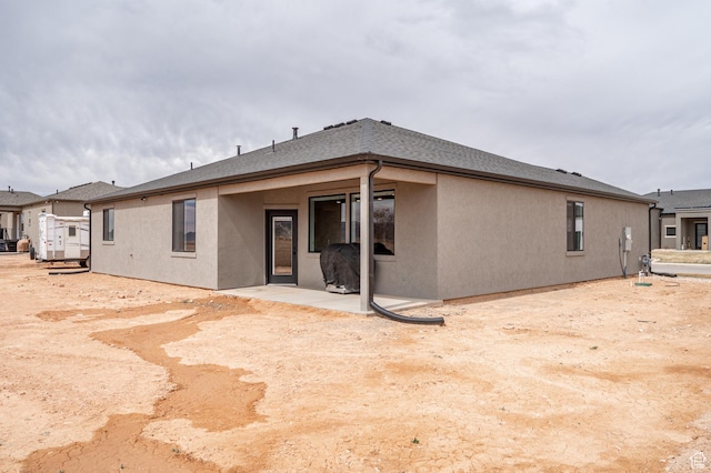 back of house with stucco siding and a patio area