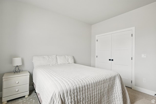 bedroom featuring a closet, baseboards, and carpet