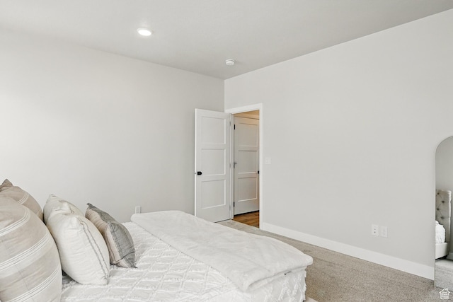 bedroom with carpet flooring, arched walkways, and baseboards