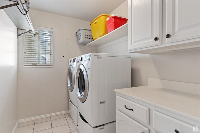 laundry room featuring independent washer and dryer, cabinet space, baseboards, and light tile patterned floors