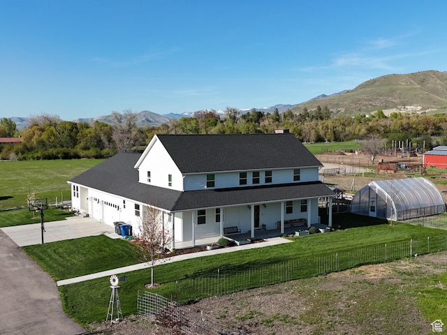 1009 E High Creek Rd, Cove, UT 84320 - rear view of property featuring an exterior structure, concrete driveway, a porch, a garage, and a mountain view