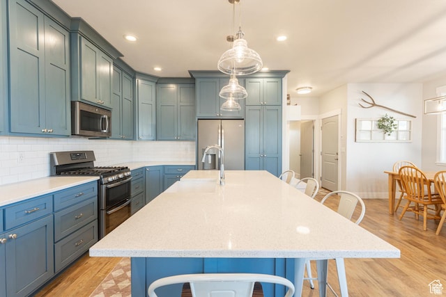 1009 E High Creek Rd, Cove, UT 84320 - kitchen with stainless steel appliances, a kitchen breakfast bar, a sink, light wood-style floors, and recessed lighting