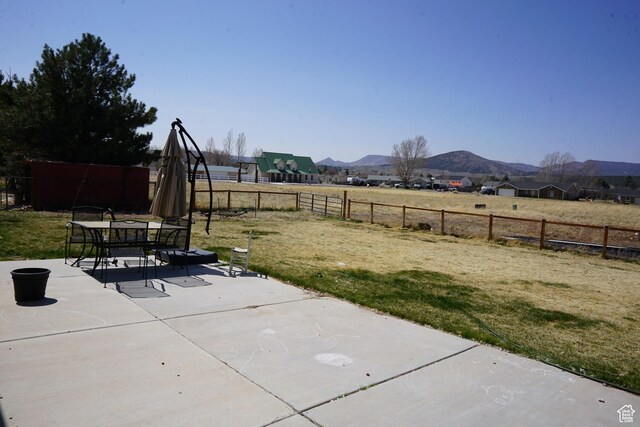 160 S 550 E Unit 18, Enterprise, UT 84725 - view of yard featuring a mountain view, a fenced backyard, outdoor dining space, and a patio area
