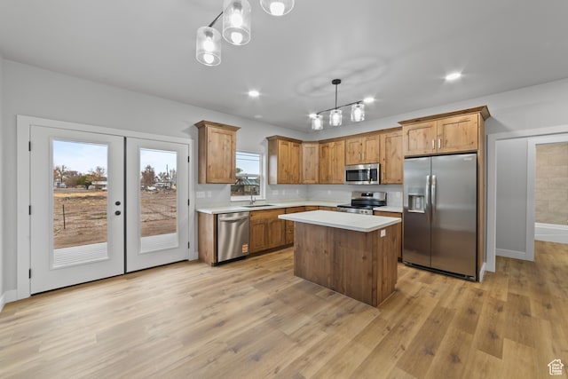 245 E Tidwell Ave Unit 5, Green River, UT 84525 - kitchen with light countertops, a center island, decorative light fixtures, light wood-style floors, and stainless steel appliances